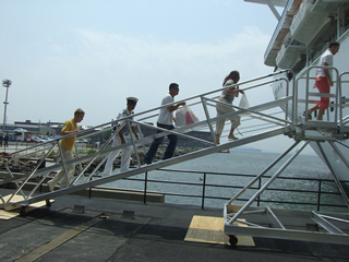 By using a dockside gangway, platform, and second gangway, the boarding system can accommodate differences in the height from the dock to the crew door.